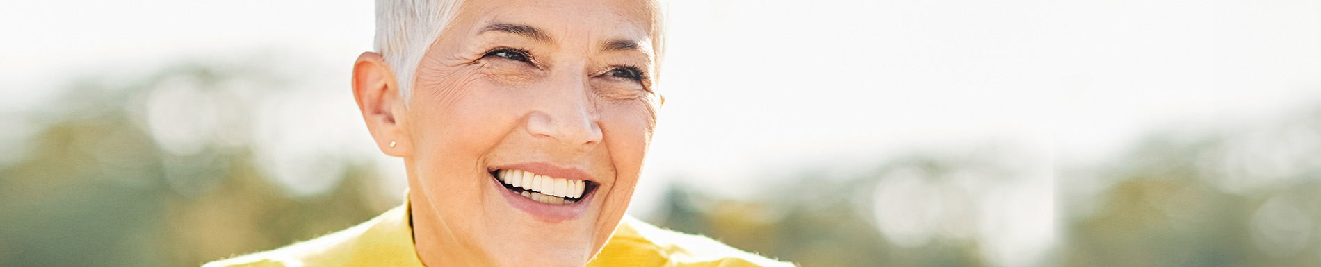 The image shows a person with a bald head smiling at the camera.