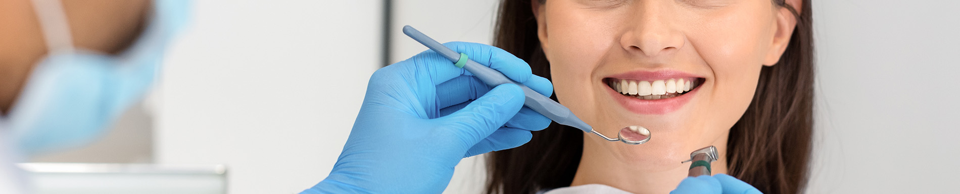 A woman undergoing dental treatment with a dentist performing the procedure.