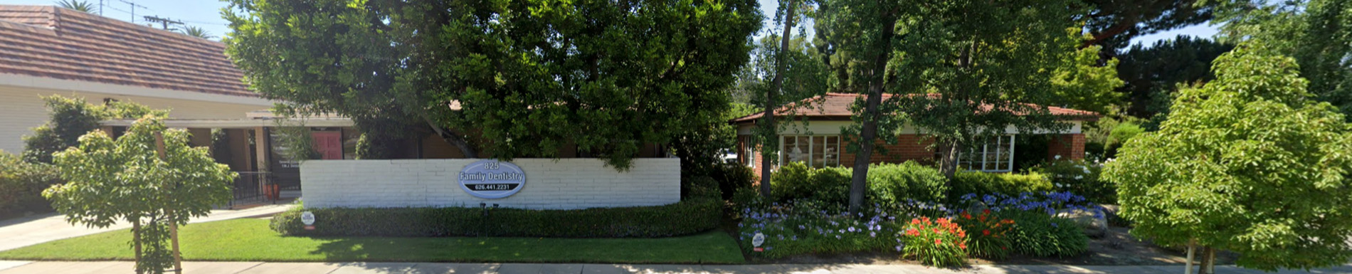 The image shows a residential area with a house, a tree, and a clear sky.