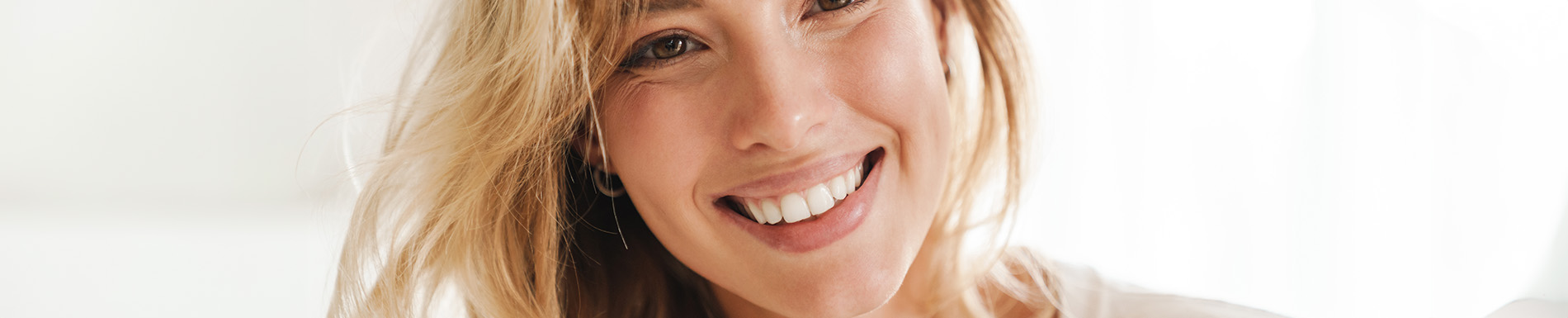 The image shows a woman with blonde hair smiling at the camera.