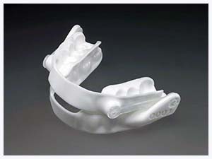 The image shows a white, anatomically detailed dental retainer with multiple teeth-like structures, displayed against a neutral background.