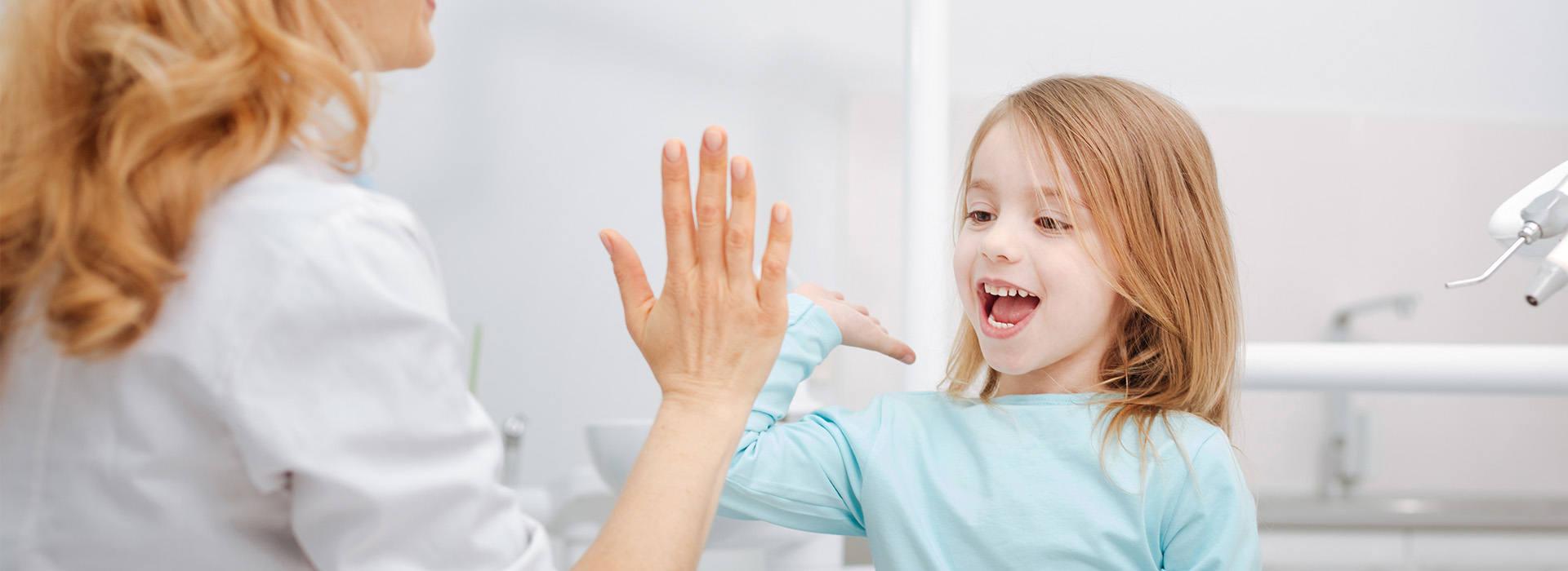 The image depicts a woman and a young girl in a bathroom setting, with the woman appearing to be showing something to the child, who is looking at her hand with interest.