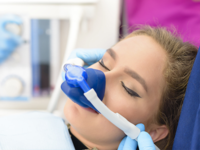 A person receiving oxygen therapy with medical equipment in a clinical setting.